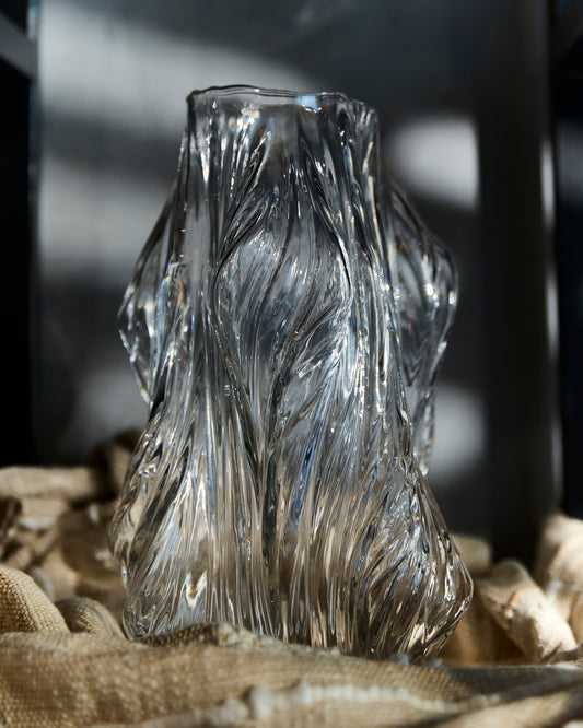 Clear glass vase with textured design on a textured surface